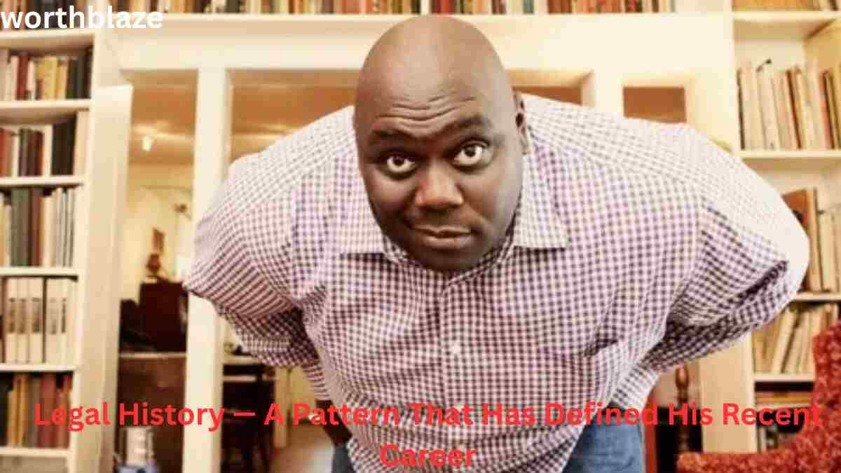 Faizon Love leaning forward in a room filled with bookshelves, featured in a discussion about Faizon Love Net Worth, legal history, career challenges, and financial journey.