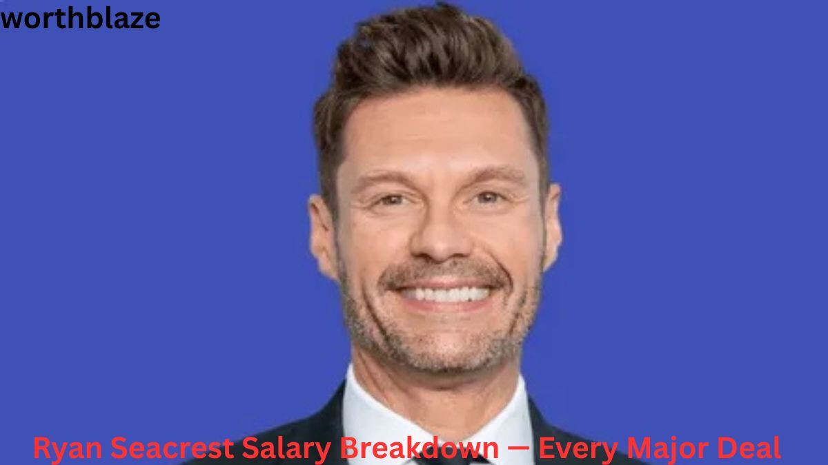 Ryan Seacrest Net Worth – Ryan Seacrest smiling in a formal studio portrait on a blue background