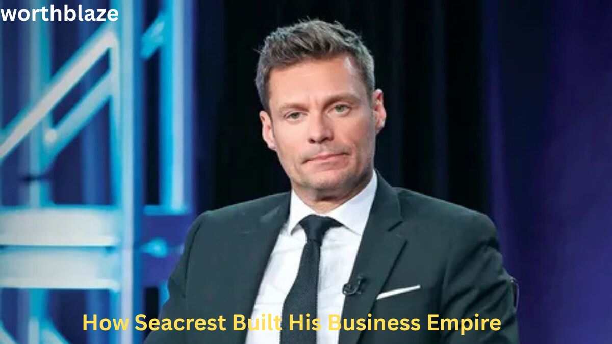 Ryan Seacrest Net Worth – Ryan Seacrest wearing a black suit during an interview, highlighting how he built his successful business empire and media career.