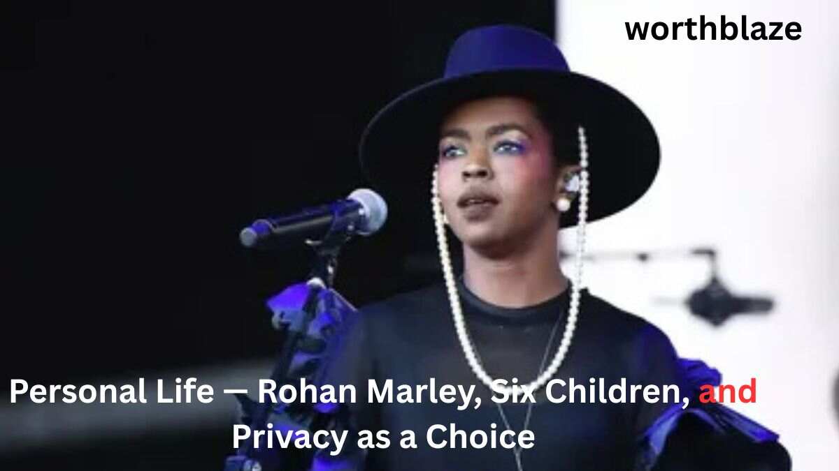 Lauryn Hill performs on stage wearing a black hat and pearl earrings during a live concert. Featured in an article about Lauryn Hill Net Worth 2026 and her personal life with Rohan Marley and their six children.